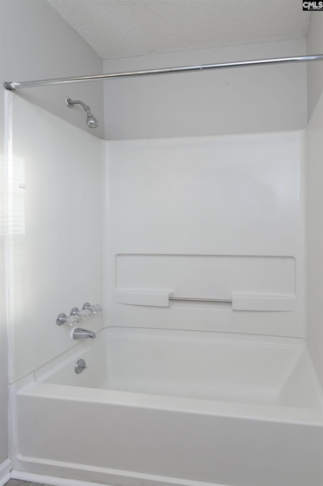 bathroom featuring a textured ceiling and tub / shower combination