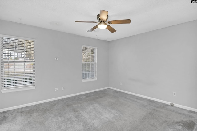 carpeted spare room with ceiling fan and plenty of natural light