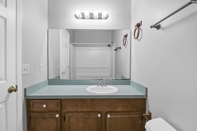 bathroom featuring walk in shower, vanity, and toilet