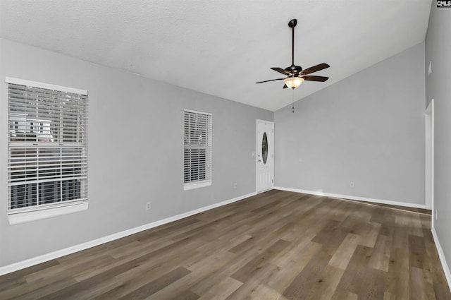 unfurnished room featuring a textured ceiling, dark wood-type flooring, ceiling fan, and lofted ceiling