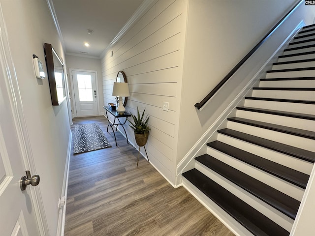 hall with ornamental molding, stairway, dark wood finished floors, and baseboards