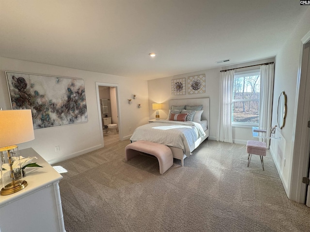 bedroom with ensuite bathroom, carpet floors, visible vents, and baseboards