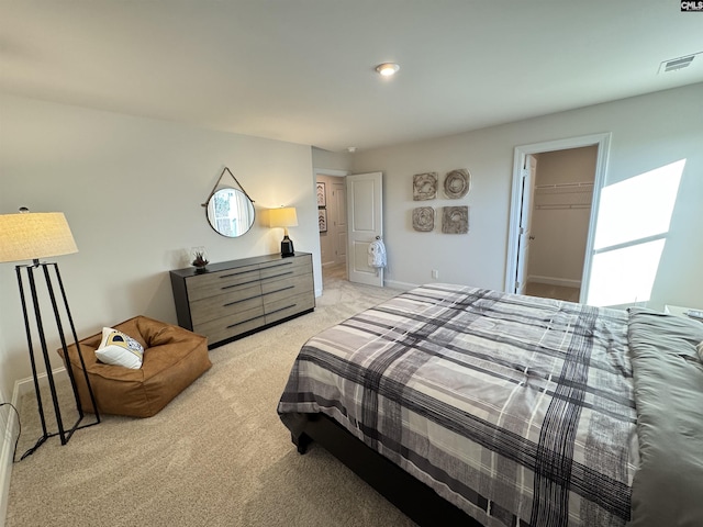 bedroom with light carpet, a spacious closet, and visible vents