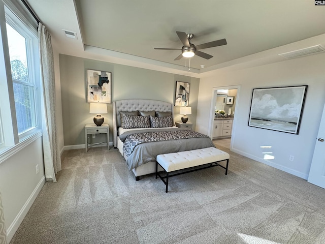 bedroom featuring carpet floors, a raised ceiling, and visible vents