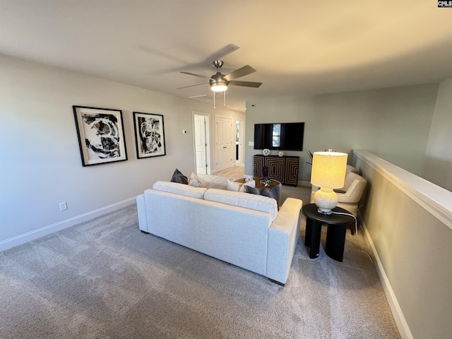 carpeted living room featuring ceiling fan and baseboards