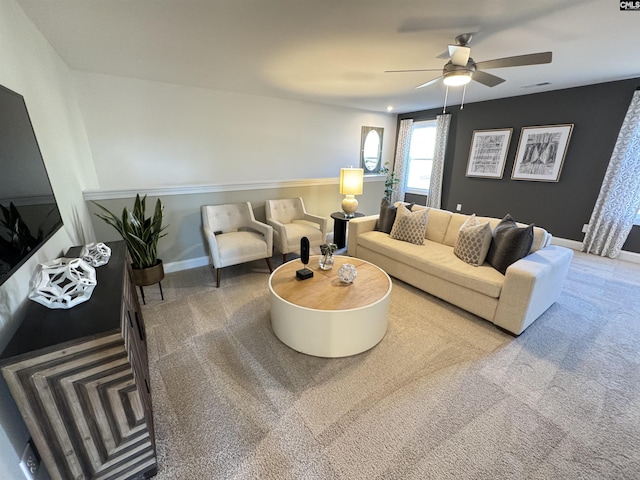 living room featuring ceiling fan, carpet flooring, visible vents, and baseboards