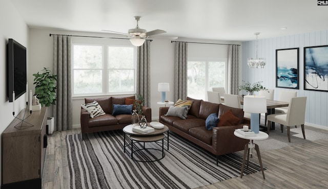 living area with baseboards, wood finished floors, and ceiling fan with notable chandelier