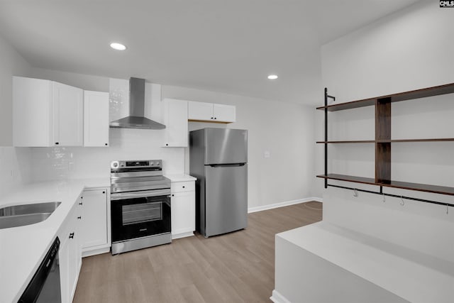 kitchen featuring backsplash, wall chimney exhaust hood, light hardwood / wood-style floors, white cabinetry, and stainless steel appliances