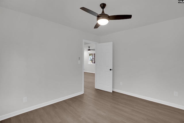 spare room featuring ceiling fan and dark wood-type flooring