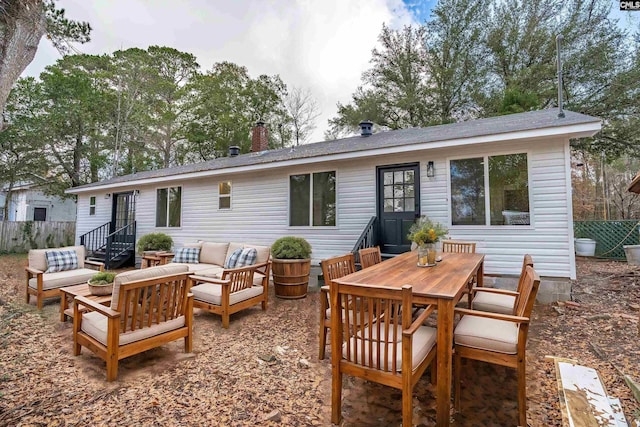 back of property featuring a chimney, fence, an outdoor hangout area, and outdoor dining space