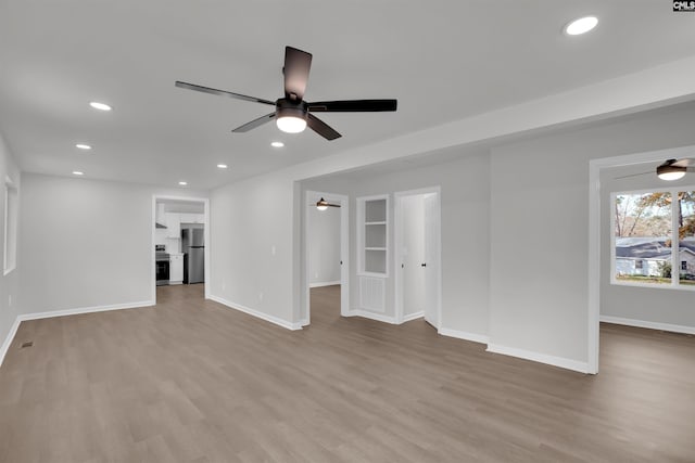 unfurnished living room with a ceiling fan, recessed lighting, and wood finished floors