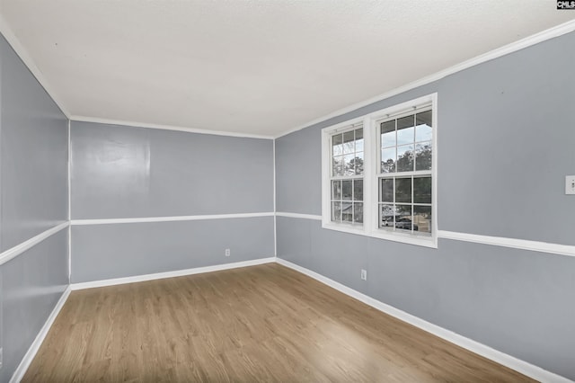 empty room featuring hardwood / wood-style flooring and crown molding