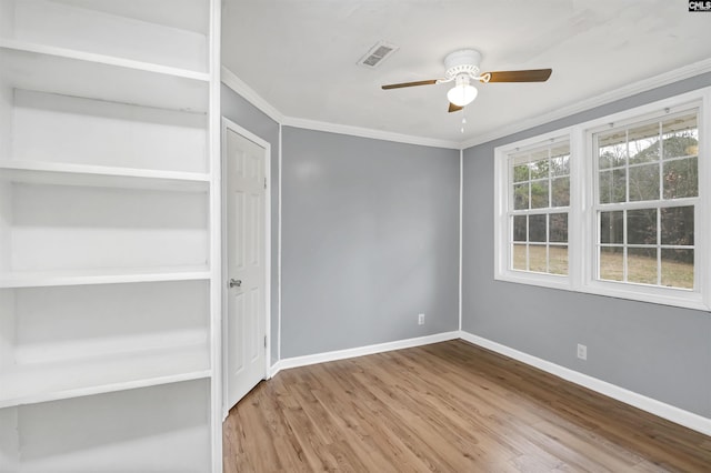 empty room featuring ceiling fan, wood-type flooring, and ornamental molding