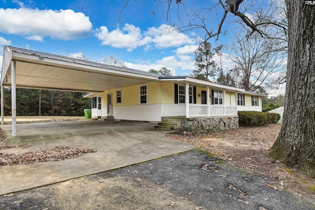 single story home featuring a porch and a carport