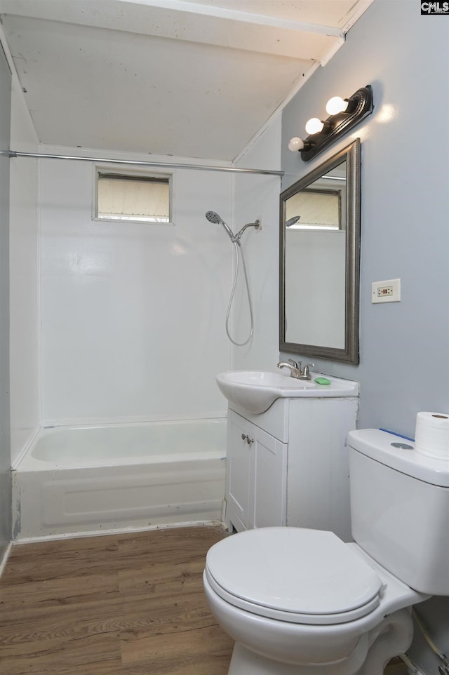 full bathroom featuring washtub / shower combination, hardwood / wood-style floors, vanity, and toilet