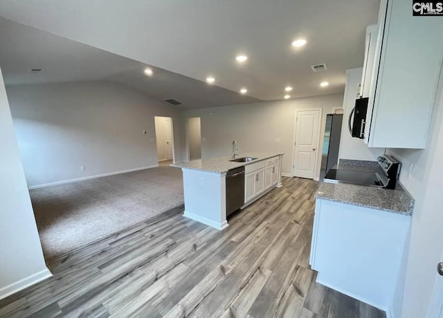 kitchen featuring white cabinets, stainless steel appliances, sink, a kitchen island with sink, and light stone counters