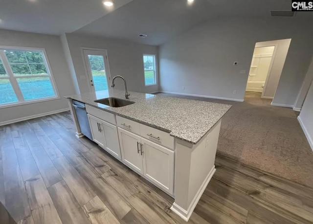 kitchen featuring dishwasher, a center island with sink, sink, light stone countertops, and white cabinets