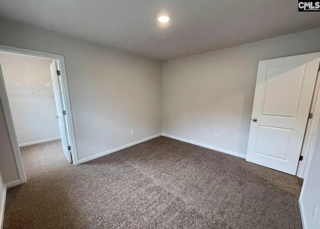 unfurnished room with dark colored carpet