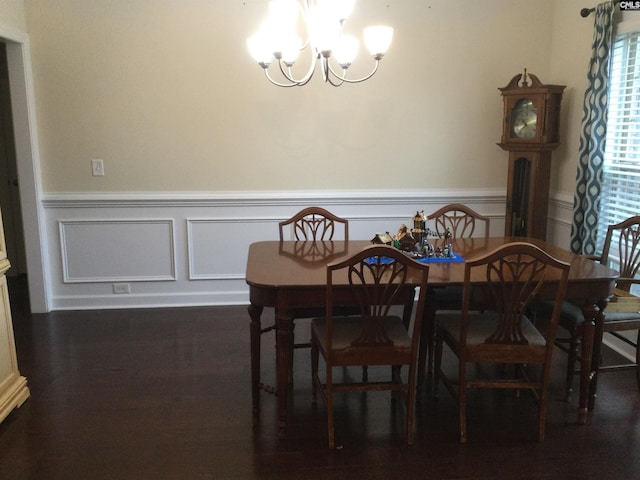 dining space featuring dark wood-type flooring and a chandelier