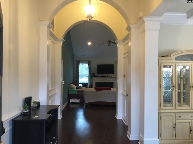 hallway featuring ornate columns and dark hardwood / wood-style floors