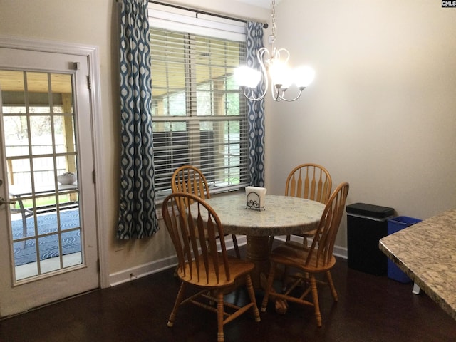 dining area with dark hardwood / wood-style floors and a notable chandelier