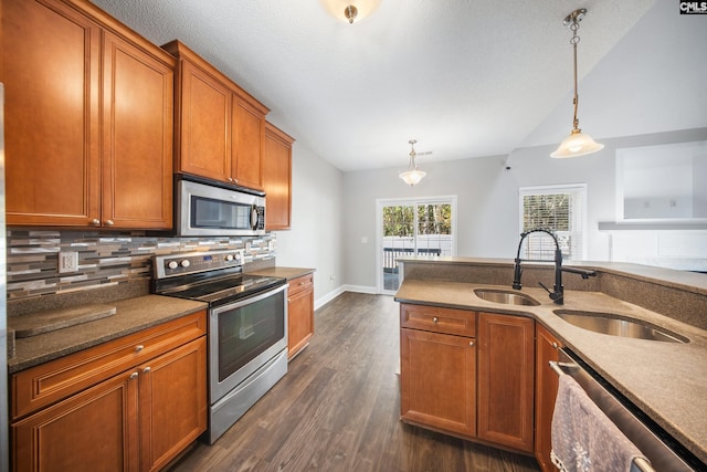 kitchen with pendant lighting, sink, decorative backsplash, appliances with stainless steel finishes, and dark hardwood / wood-style flooring