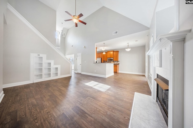 unfurnished living room featuring high vaulted ceiling, built in features, ceiling fan, and hardwood / wood-style flooring