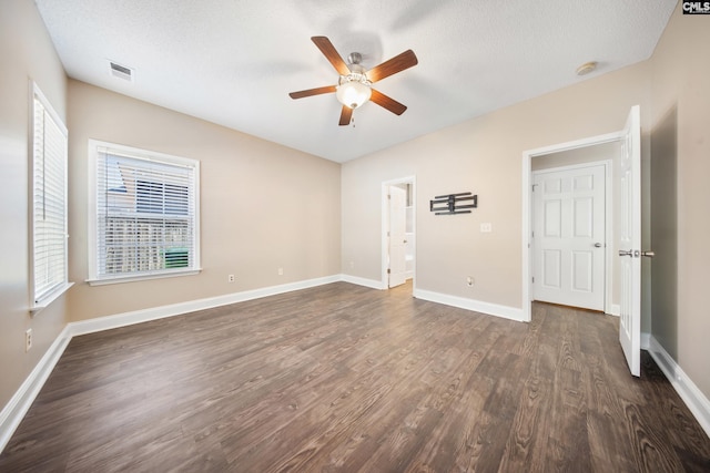 interior space featuring dark hardwood / wood-style floors, ceiling fan, a healthy amount of sunlight, and a textured ceiling