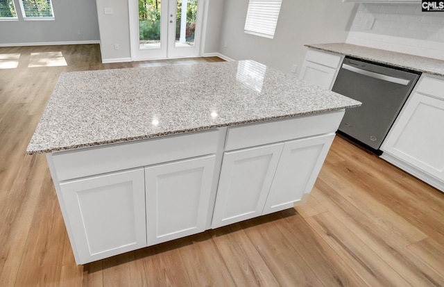 kitchen with dishwasher, a wealth of natural light, white cabinetry, and light stone countertops