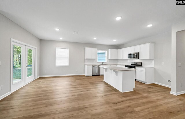 kitchen featuring a breakfast bar area, white cabinetry, a center island, and stainless steel appliances