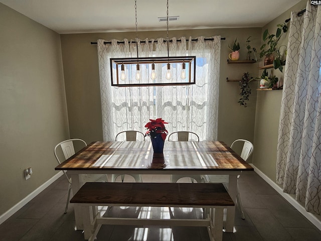 dining space featuring dark tile patterned floors