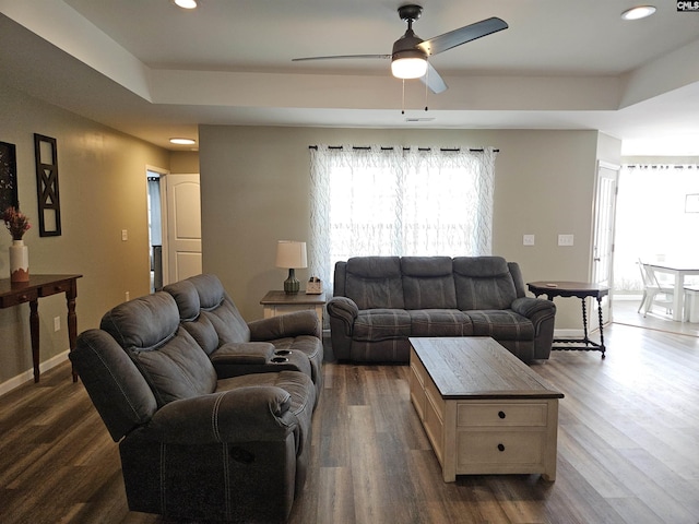 living room with ceiling fan and dark wood-type flooring