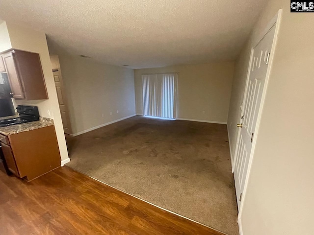 unfurnished living room featuring carpet floors and a textured ceiling