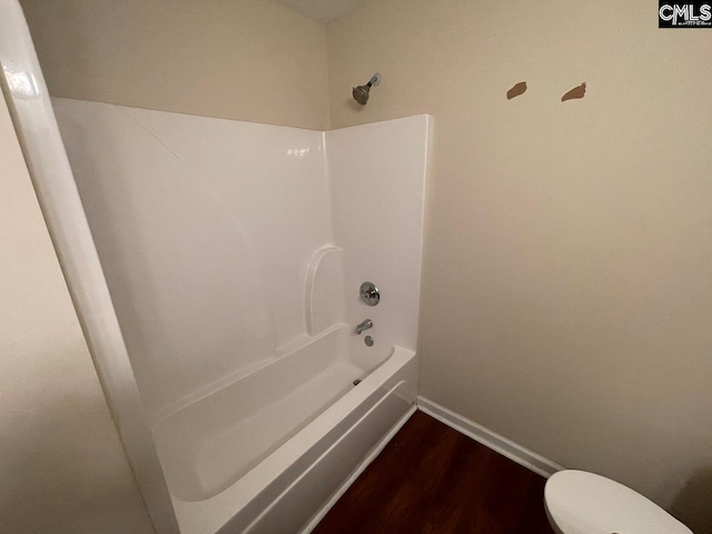 bathroom featuring wood-type flooring, toilet, and shower / bathtub combination