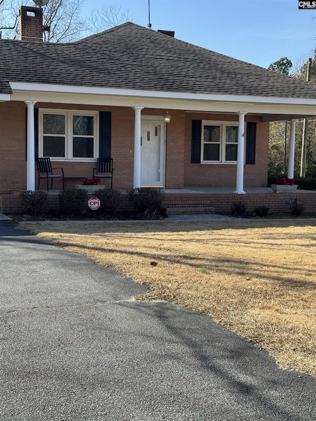 single story home with covered porch and a front lawn