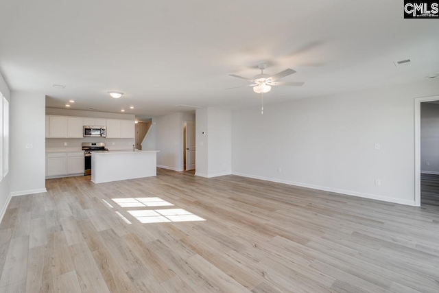 unfurnished living room featuring ceiling fan and light wood-type flooring