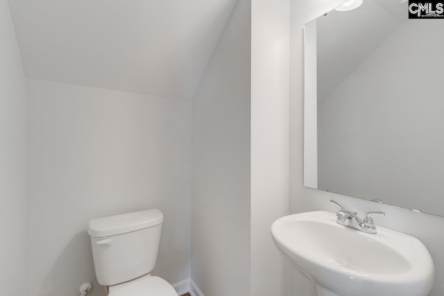 bathroom featuring vaulted ceiling, toilet, and sink