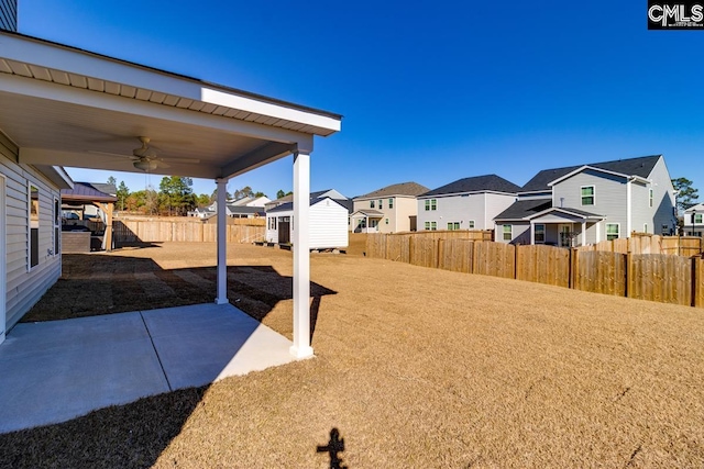 view of yard featuring ceiling fan and a patio