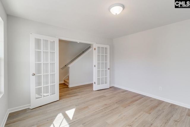 unfurnished room featuring french doors and light wood-type flooring