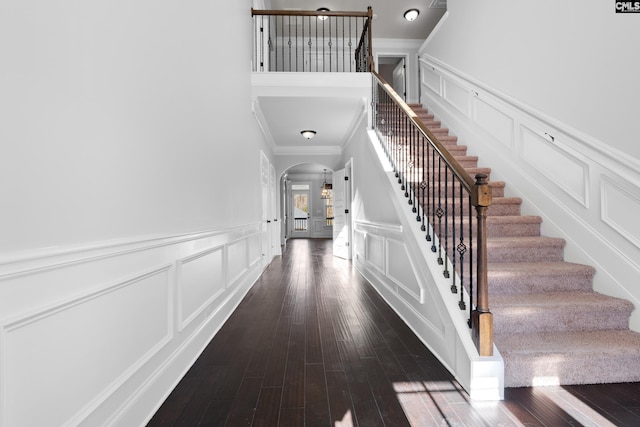 staircase featuring wood-type flooring and ornamental molding