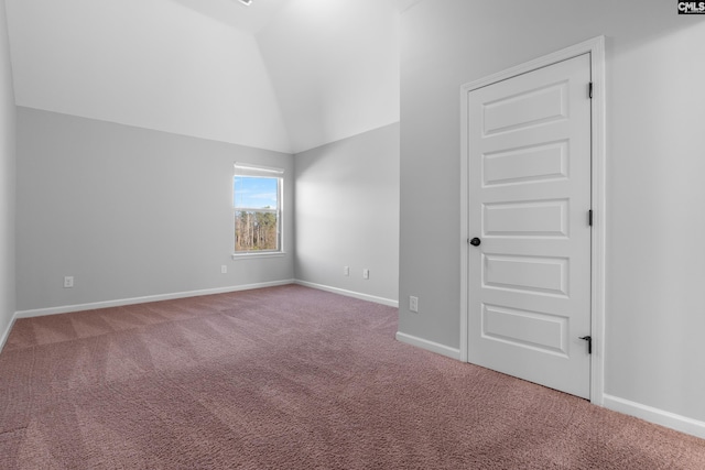 unfurnished room featuring carpet and lofted ceiling