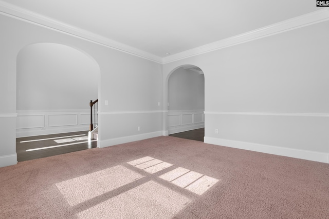 empty room featuring dark colored carpet and ornamental molding