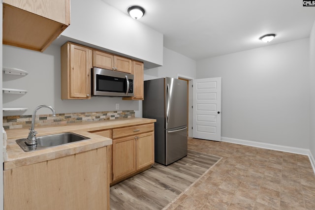 kitchen with backsplash, sink, stainless steel appliances, and light brown cabinets