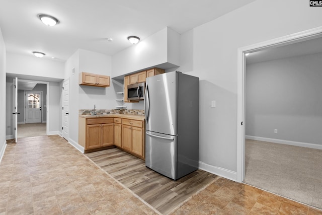 kitchen featuring light brown cabinets, light colored carpet, sink, and appliances with stainless steel finishes