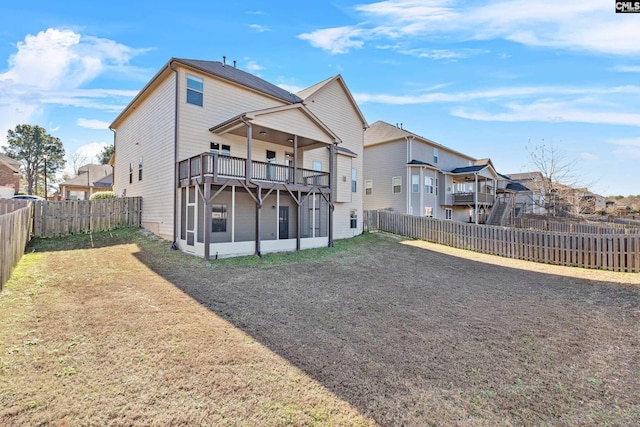 back of house with a sunroom, a balcony, and a yard