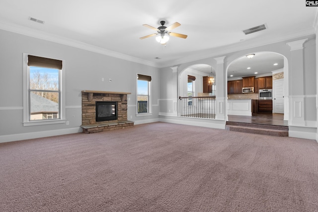 unfurnished living room with dark colored carpet, a fireplace, crown molding, and ceiling fan