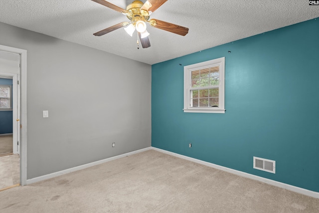 carpeted empty room with ceiling fan and a textured ceiling