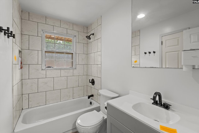 full bathroom with vanity, tiled shower / bath combo, and toilet