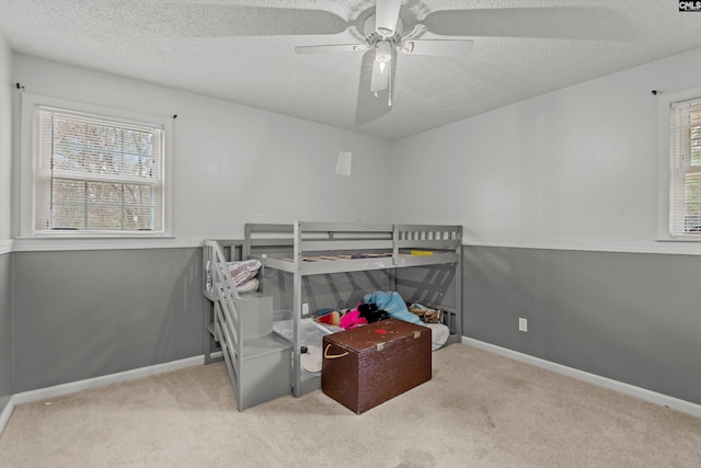 carpeted bedroom featuring a textured ceiling and ceiling fan