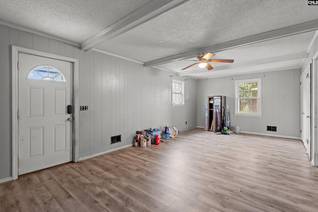 entrance foyer with ceiling fan, light hardwood / wood-style flooring, beamed ceiling, and a textured ceiling